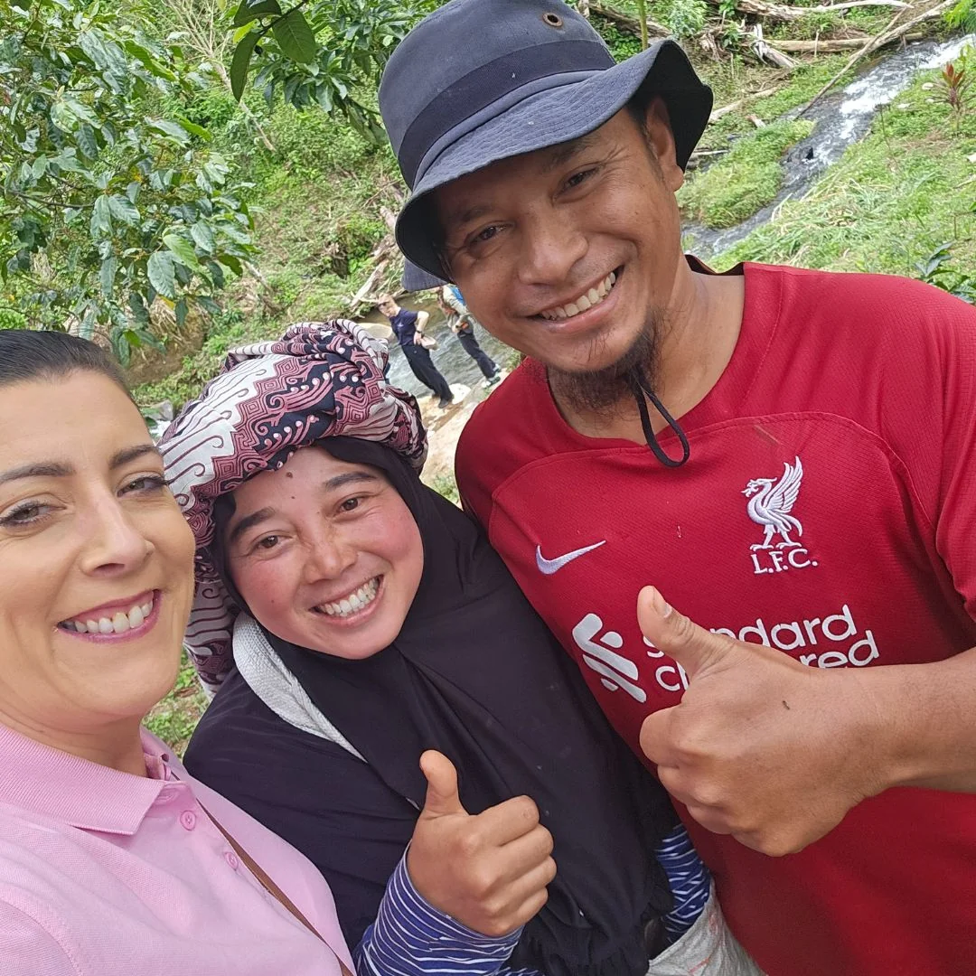 three people smiling and holding thumbs up